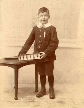 All dressed up, a little boy proudly displays his tin soldiers. Toy soldiers are rarely played with now, and examples like these are now treated as antiques.