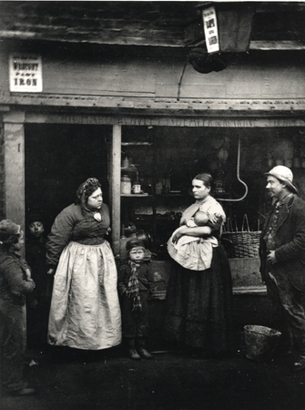 Adults and children outside an iron shop
