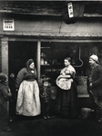Adults and children outside an ironmongers