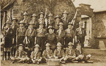 With the exception of their broad-rimmed hats, scouting uniform is very similar today. Each troop would have its own markings which appeared on the children's shirts and on their flags. Matron sits proudly in the middle as Akela.