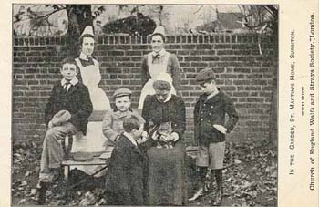 Sitting on Matron's knee, the Home's cat forms the centre of attention in this group photograph. The Society believed that keeping a pet encouraged children to be responsible, and taught them 'the many lessons which the care of some gentle, loveable animal would give.' 